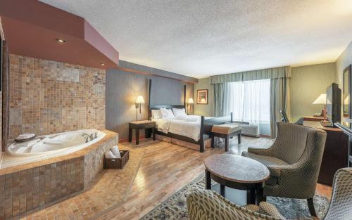 Hampton Inn & Suites by Hilton Moncton في مونكتون: غرفة في الفندق مع حوض استحمام وسرير