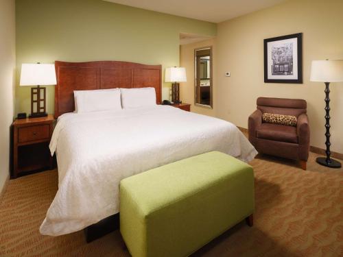 a hotel room with a large bed and a chair at Hampton Inn Cleveland Tennessee in Cleveland