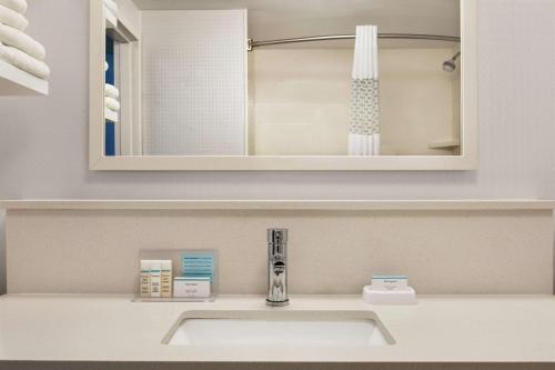 a bathroom with a sink and a mirror at Hampton Inn London Ontario in London