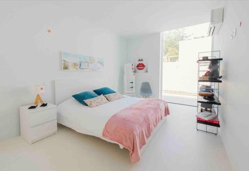 Contemporary Beach House Cabedelo في فيانا دو كاستيلو: غرفة نوم بيضاء مع سرير كبير ونافذة