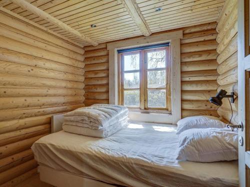 Cama en habitación de madera con ventana en Holiday home Eskebjerg XI en Eskebjerg