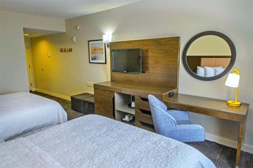 a hotel room with a bed and a desk and a mirror at Hampton Inn & Suites Chesapeake-Battlefield Boulevard in Chesapeake