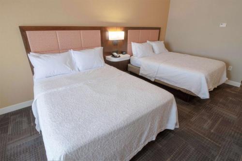 a hotel room with two beds with white sheets at Hampton Inn & Suites Chesapeake-Battlefield Boulevard in Chesapeake