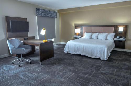 a hotel room with a bed and a desk and a chair at Hampton Inn & Suites Chesapeake-Battlefield Boulevard in Chesapeake