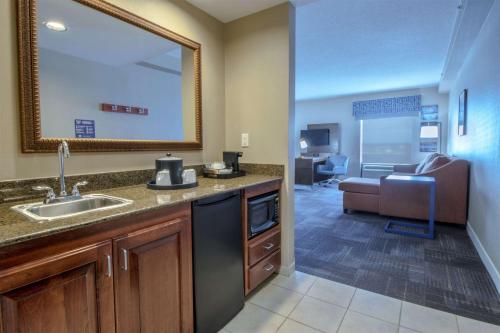 a kitchen with a sink and a living room at Hampton Inn & Suites Chesapeake-Battlefield Boulevard in Chesapeake