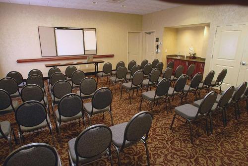a conference room with chairs and a podium and a screen at Hampton Inn & Suites Chesapeake-Battlefield Boulevard in Chesapeake