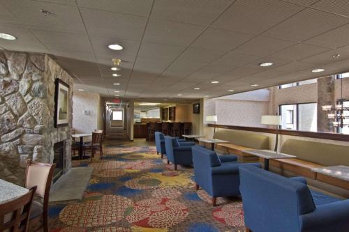 a waiting room with chairs and tables and a stone wall at Hampton Inn & Suites Chillicothe in Chillicothe