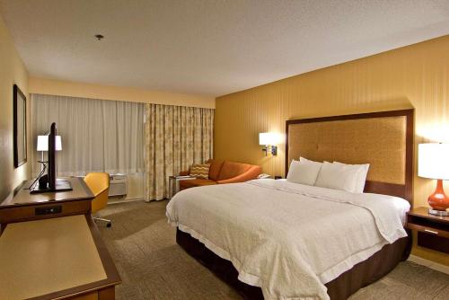 a hotel room with a large bed and a chair at Hampton Inn & Suites Chillicothe in Chillicothe