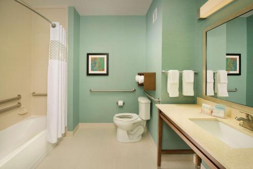 a bathroom with a toilet and a tub and a sink at Hampton Inn Lake Charles in Lake Charles