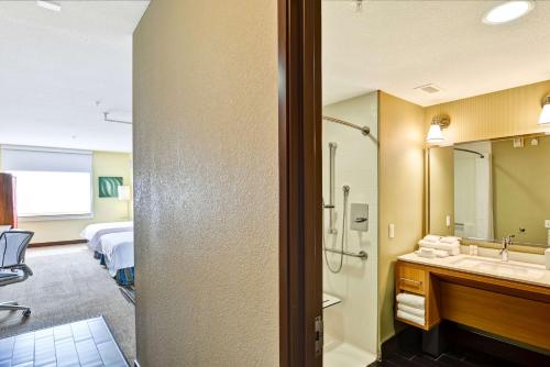 a hotel room with a bathroom with a shower and a sink at Home2 Suites by Hilton Albuquerque Downtown/University in Albuquerque