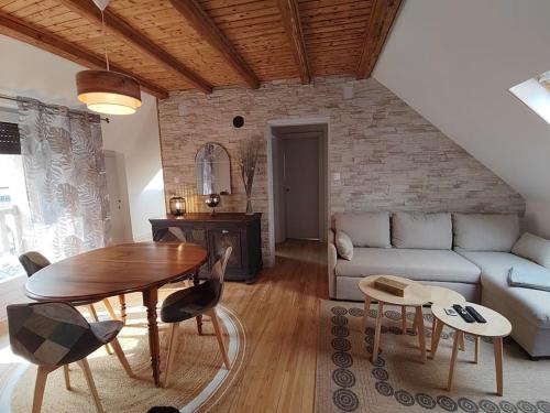 a living room with a couch and a table at Appartement indépendant avec extérieur in Epfig