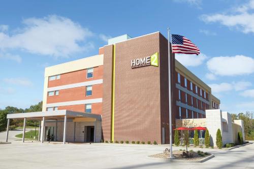 an office building with an american flag in front of it at Home2 Suites by Hilton Canton in North Canton