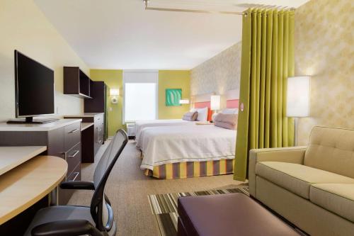 Home2 Suites by Hilton Canton في كانتون الشمالية: غرفة في الفندق مع غرفة نوم مع سرير ومكتب