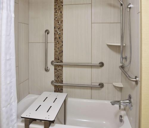 a bathroom with a white tub and a sink at Homewood Suites Davenport in Bettendorf