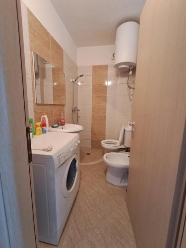 ein Badezimmer mit einer Waschmaschine und einem WC in der Unterkunft Beach view Apartment in Vlorë