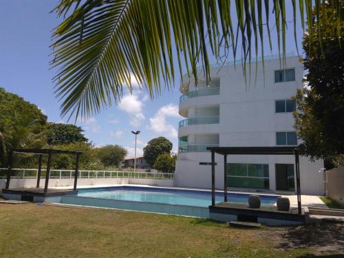 ein Gebäude mit einem Pool neben einem Gebäude in der Unterkunft Flat de frente ao mar in Conde