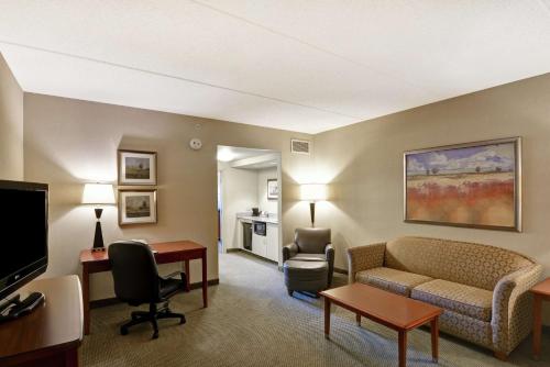 um quarto de hotel com um sofá e uma cadeira e uma televisão em Hampton Inn Sayre em Sayre