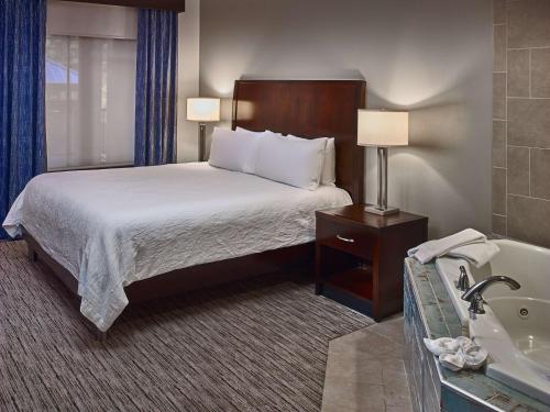 a hotel room with a bed and a bath tub at Hilton Garden Inn Gatlinburg in Gatlinburg
