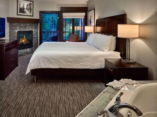 um quarto de hotel com uma cama e uma lareira em Hilton Garden Inn Gatlinburg em Gatlinburg