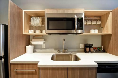 a kitchen with a sink and a microwave at Home2 Suites By Hilton San Francisco Airport North in South San Francisco
