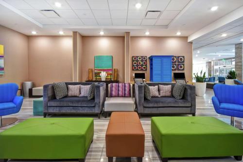 a waiting room with couches and tables in a lobby at Home2 Suites By Hilton San Francisco Airport North in South San Francisco