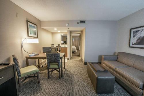 a living room with a couch and a table in a room at Embassy Suites by Hilton Chicago Schaumburg Woodfield in Schaumburg