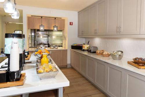 Una cocina con gabinetes blancos y una encimera blanca. en Hilton Garden Inn Saint Augustine Beach, en St. Augustine Beach