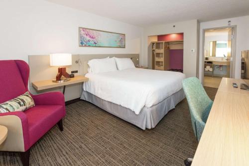 a hotel room with a bed and a desk and a chair at Hilton Garden Inn Saint Augustine Beach in Saint Augustine Beach