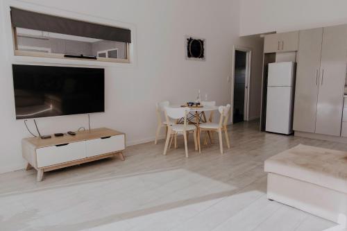 a white living room with a table and a white refrigerator at Meadowbank Lakehouse in Ellendale