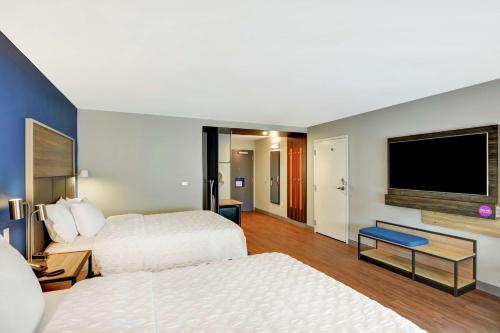 a hotel room with two beds and a flat screen tv at Tru By Hilton Middletown in Middletown