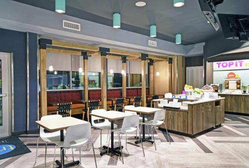 a restaurant with white chairs and tables and a counter at Tru By Hilton Portland Airport Area Me in South Portland