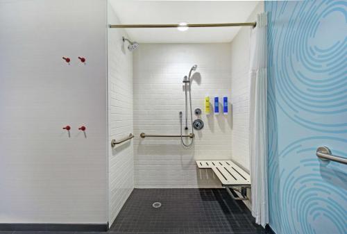 a shower stall with a bench in a bathroom at Tru By Hilton Portland Airport Area Me in South Portland