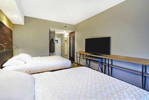 a hotel room with two beds and a flat screen tv at Tru By Hilton Portland Airport Area Me in South Portland