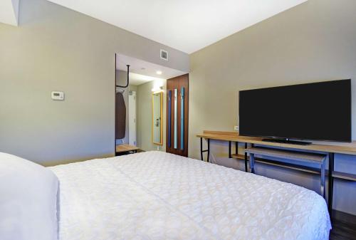 a hotel room with a bed and a flat screen tv at Tru By Hilton Portland Airport Area Me in South Portland
