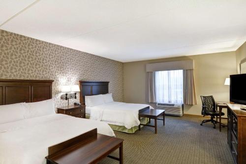 a hotel room with two beds and a flat screen tv at Hampton Inn Tunkhannock in Tunkhannock