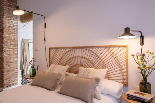 um quarto com uma cama branca e uma cabeceira em madeira em APARTAMENTO JUNTO A HOSPITAL REAL em Granada