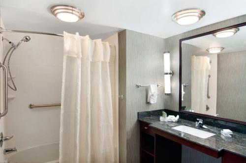 a bathroom with a shower and a sink and a mirror at Homewood Suites by Hilton Slidell in Slidell