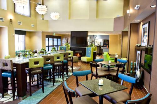 a restaurant with tables and chairs and a fireplace at Hampton Inn & Suites Salt Lake City/Farmington in Farmington