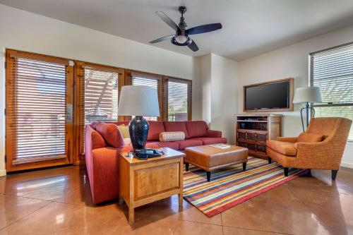 a living room with a couch and a tv at Hilton Grand Vacations Club Palm Desert in Palm Desert