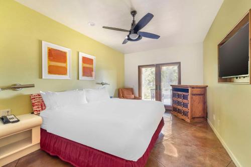 a bedroom with a large white bed and a flat screen tv at Hilton Grand Vacations Club Palm Desert in Palm Desert