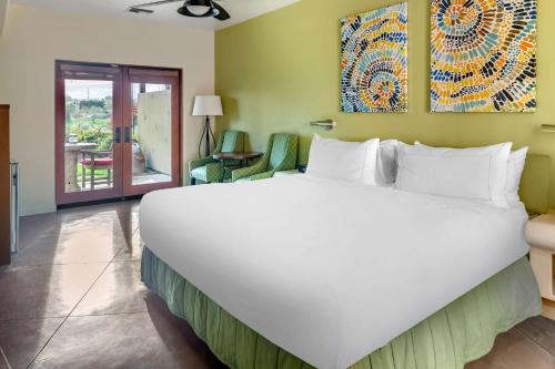 a bedroom with a large white bed in a room at Hilton Grand Vacations Club Palm Desert in Palm Desert