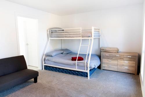 a bedroom with a bunk bed and a couch at Meadowbank Lakehouse in Ellendale