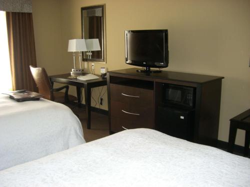 a hotel room with a bed and a flat screen tv at Hampton Inn and Suites Pueblo/North in Pueblo