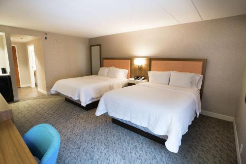 a hotel room with two beds with white sheets at Hampton Inn Clarks Summit in Clarks Summit