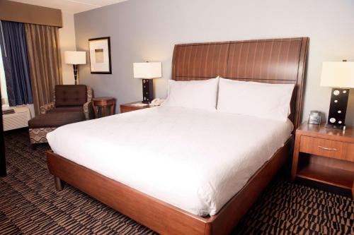 a hotel room with a large bed and a chair at Hilton Garden Inn Austin NorthWest/Arboretum in Austin