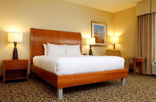 a hotel room with a large bed and two lamps at Hilton Garden Inn Cedar Falls Conference Center in Cedar Falls