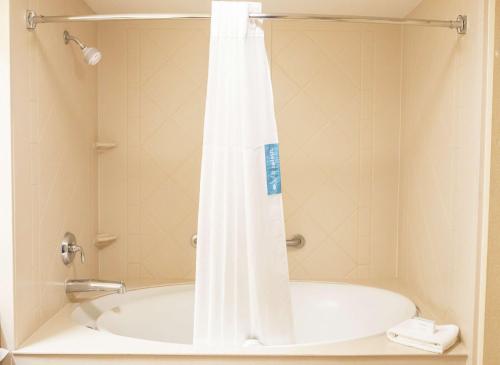 a bath tub with a shower curtain in a bathroom at Hampton Inn & Suites Lathrop in Lathrop
