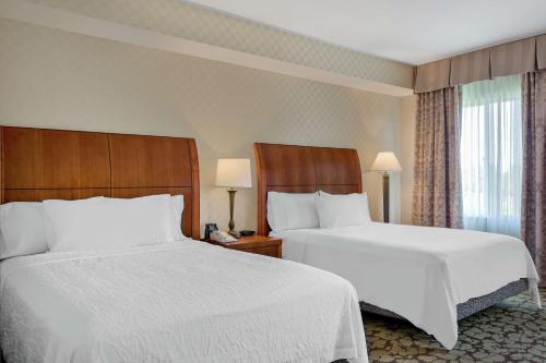 2 łóżka w pokoju hotelowym z białą pościelą w obiekcie Hilton Garden Inn Sacramento Elk Grove w mieście Elk Grove