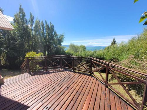 a wooden deck with a wooden railing on top of it at Casa Lago Argentino in El Calafate