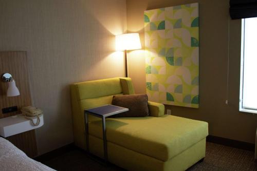 a hotel room with a yellow chair and a lamp at Hampton Inn Boise - Airport in Boise